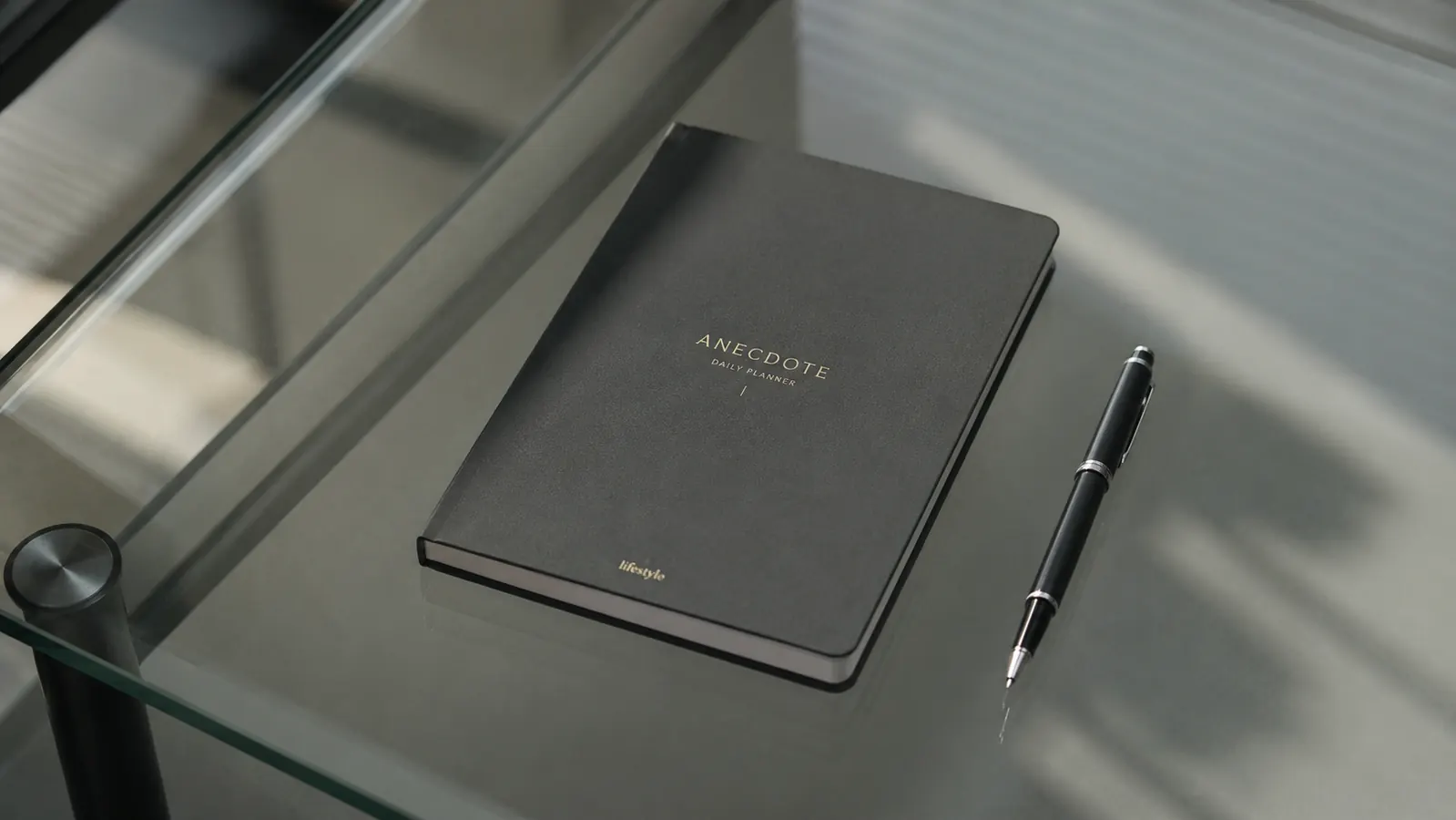 Anecdote Daily Planner closed on a desk next to a pen, showing the matte cover under cool office lighting