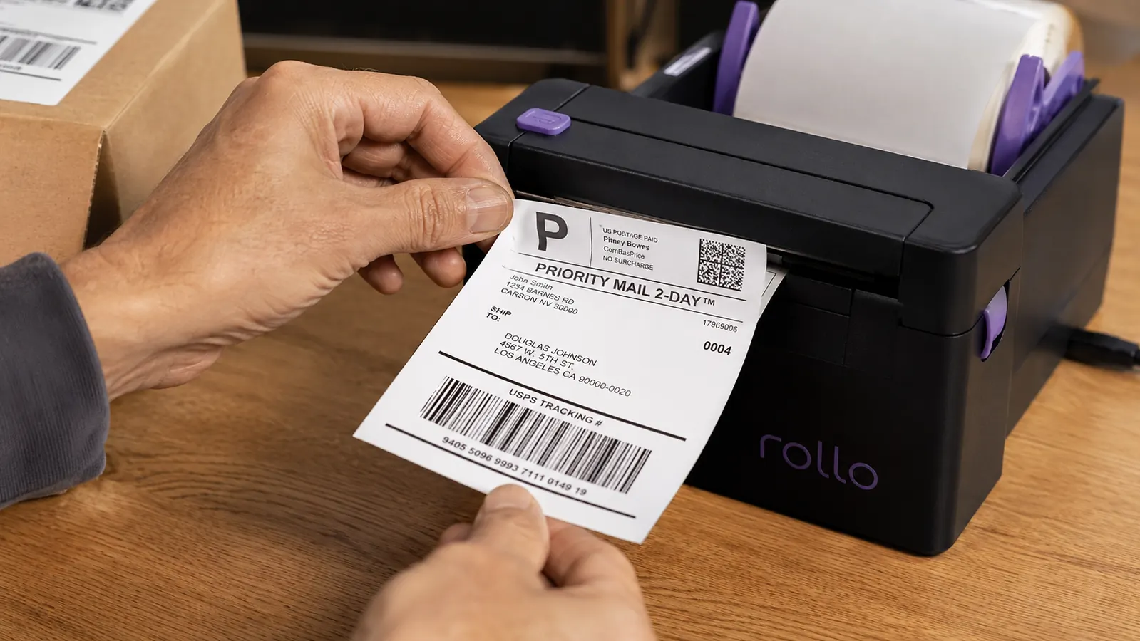Hand peeling a freshly printed 4x6 thermal shipping label from the Rollo printer