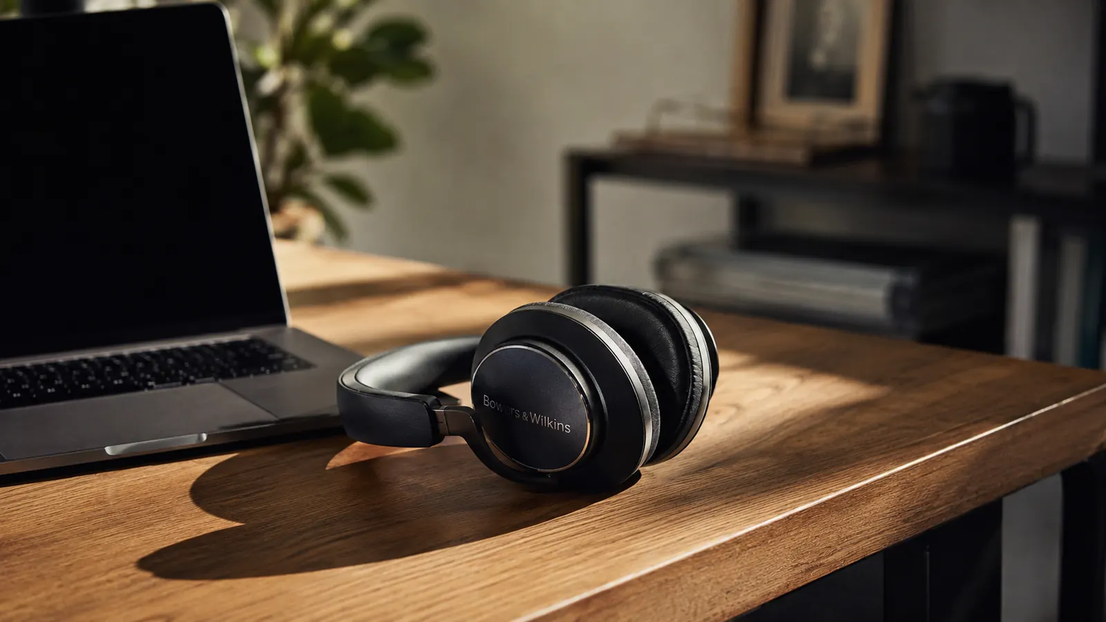 Sony WH-1000XM5 headphones on a clean modern desk next to a MacBook in a home office